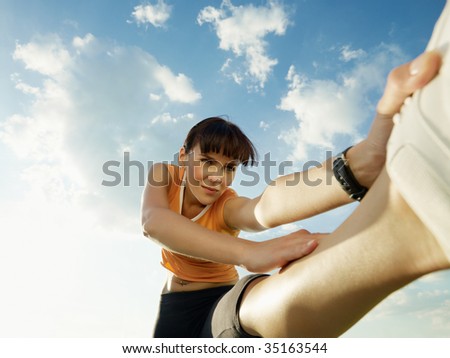 woman doing stretching outdoors at sunset. Low angle view, copy space