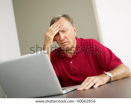 Senior man having headache while using laptop. Copy space