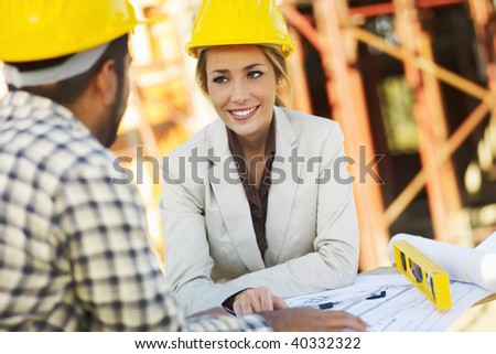latin american construction worker and female architect talking. Copy space