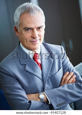 portrait of mature business man with arms folded, looking at camera. Copy space