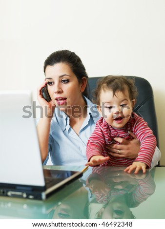 stressed business woman in office, holding her little girl while talking on mobile phone. Vertical shape, Copy space