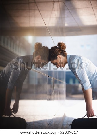 mid adult italian business woman banging her head against a wall outside office building. Vertical shape, copy space