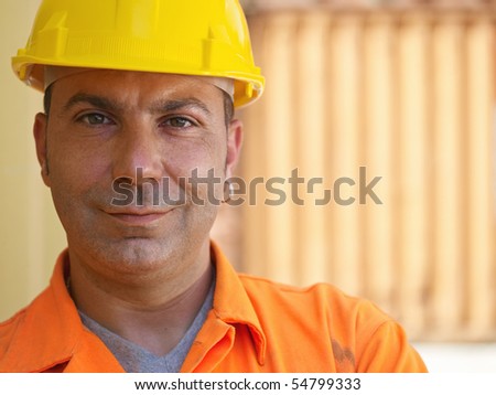 portrait of mid adult worker standing near cargo containers and looking at camera. Horizontal shape, front view, copy space