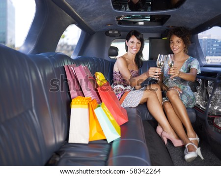 women in limousine toasting with champagne. Horizontal shape, full length, copy space