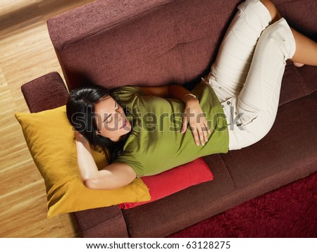 Woman lying down on sofa. Horizontal shape, high angle view, three quarter length, copy space