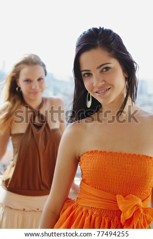 young caucasian female couple looking at camera and smiling. Vertical shape, waist up, front view