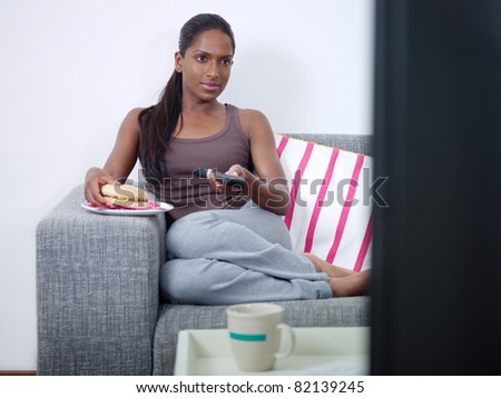 First, what is sex? Sex can mean a lot of different things to a lot of ... stock photo mid adult indian woman on sofa changing tv channel with remote control and eating junk food front 82139245 First, what is sex? Sex can mean a lot of different things to a lot of ...