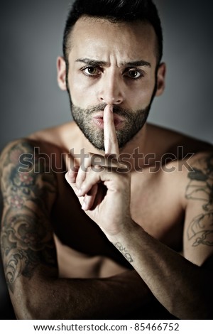 stock photo portrait of proud young adult man with tattoos hissing