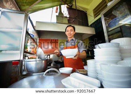 Chef preparing traditional Asian street food and working in the restaurant kitchen. Horizontal shape, front view