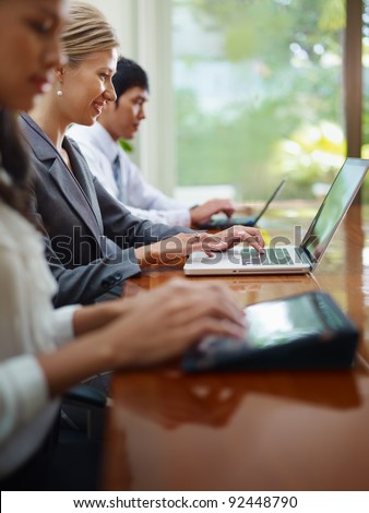 Group of businesspeople meeting in conference room and using laptop computers. Side view, copy space