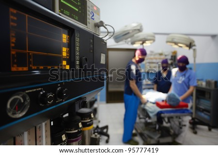 Team work with doctors, nurses, surgeons performing surgery on sick patient in hospital operation room. Focus on foreground