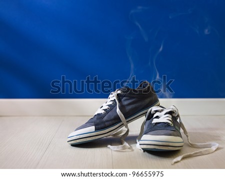 concept shot of feet perspiration: bad smell coming out from old and dirty shoes