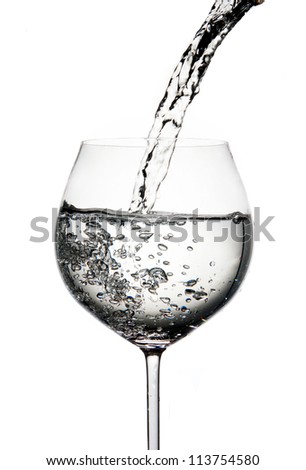 Pouring water into glass isolated