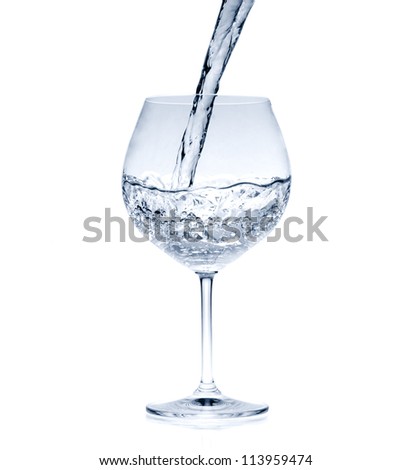 Pouring water into glass (splash of water) isolated on white
