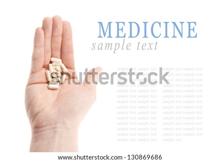 White pills on hand isolated on white background