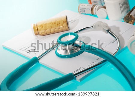 Empty medical prescription with a sthetoscope and medicine bottles  on blue reflective background