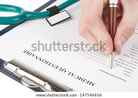 Hand filling in medical questionnaire form in a clipboard isolated on white background