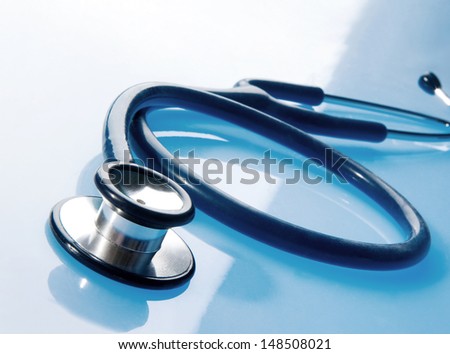 Stethoscope on blue, reflective background