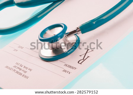 Empty medical prescription with a stethoscope on blue reflective background