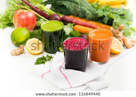 Fresh Carrot, Beets, and Greens Juices on White Background