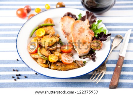 Thin Pork Chops Served with Sauteed Potatoes, Green Beans, Cherry Tomatoes and Greens