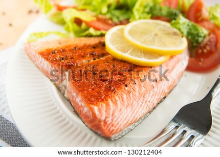 Grilled Salmon Filet Served with Tomatoes and Romaine Salad