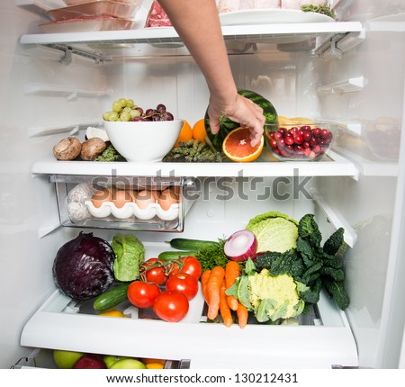 Child Reaching for Snack in Refrigerator Full of Healthy Food Options