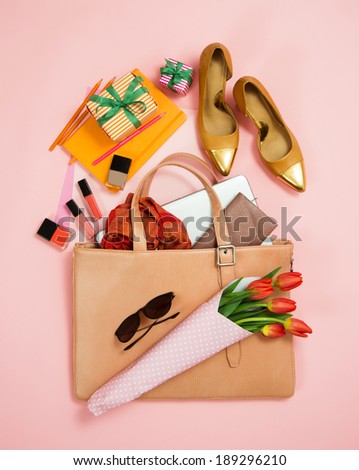 Large Simple Pink Woman's Business Briefcase with Various Items in it on Pink Background