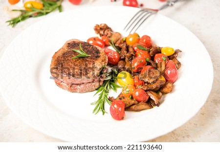 Yellow Chanterelle Mushrooms Cooked in Butter and Wine with Cherry Tomatoes Served with Medium Rare Fillet Mignon