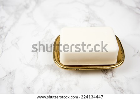 Bar of Artisan White Soap in Vintage Dish Sitting on White Marble Counter