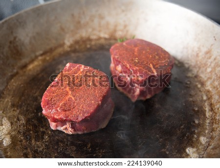 Two Filet Mignon Steaks Being Cooked on Hot Stainless Steel Skillet