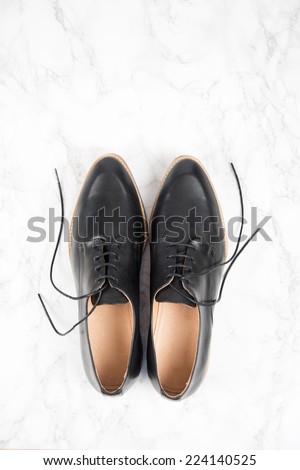 Black Oxford Style Modern Formal Shoes on White Marble Floor
