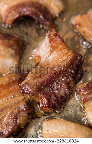Closeup of  Pork Belly Cooking in Stainless Steel Skillet