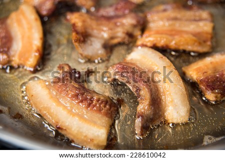 Rendering Fat out of Pieces of Pork Belly in Stainless Steel Skillet