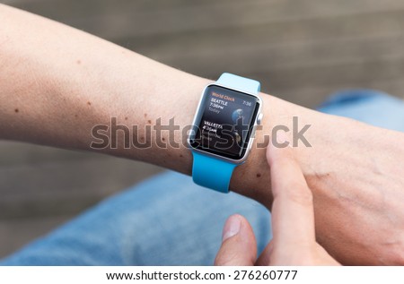 SEATTLE, USA - May 8, 2015: Man Using World Clock App on Apple Watch While Outside. Seattle, USA  and Valetta, Malta times.