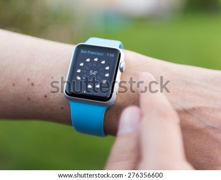 SEATTLE, USA - May 8, 2015: Man Using Weather App on Apple Watch. Showing San Fransisco Weather Forecast.