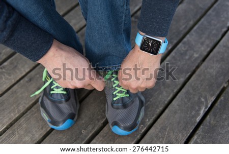 SEATTLE, USA - May 8, 2015: Man Tying His Sneakers While Wearing Apple Watch.