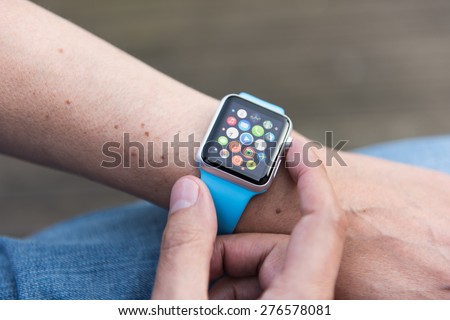 SEATTLE, USA - May 8, 2015: Man Using App on Apple Watch While Outside. Multiple Apps View.
