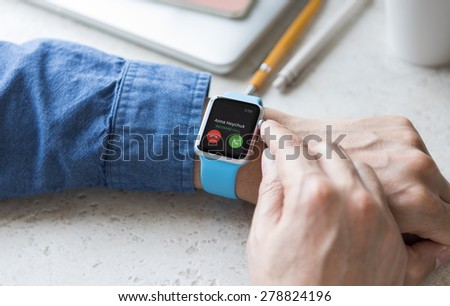 SEATTLE, USA - May 17, 2015: Man Wearing Sport Apple Watch with Blue Rubber Band. Phone Call Incoming.