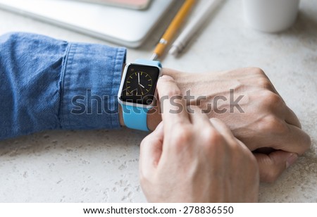 SEATTLE, USA - May 17, 2015: Man Wearing Sport Apple Watch with Blue Rubber Band. Analog Watch View.