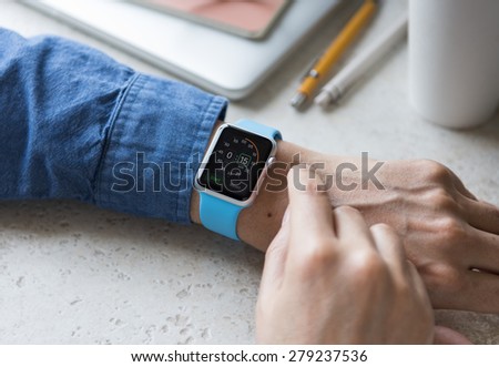 SEATTLE, USA - May 19, 2015: Man Wearing Sport Apple Watch with Blue Rubber Band. Stopwatch View.