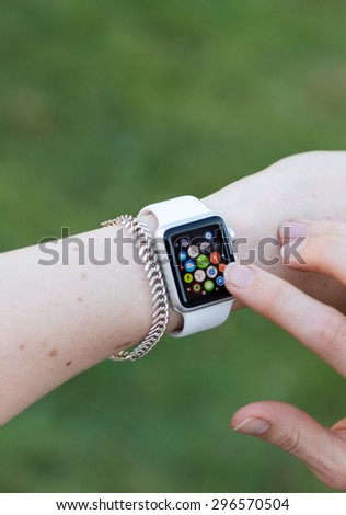 SEATTLE, USA - July 15, 2015: Woman Using Apple Watch While Outside. Multiple Apps View.