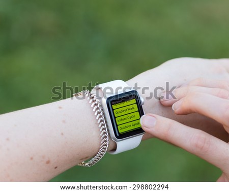 SEATTLE, USA - July 22, 2015: Woman Using Apple Watch While Outside. Using Activity App to Track Distance and Calories Per Workout.