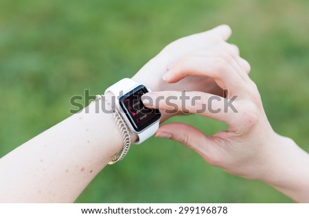 SEATTLE, USA - July 23, 2015: Woman Using Apple Watch While Outside. Using Music App to Play Songs.