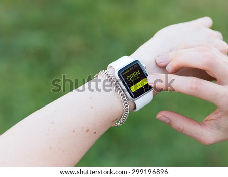 SEATTLE, USA - July 23, 2015: Woman Using Apple Watch While Outside. Using Activity App to Track Distance and Calories Per Workout.