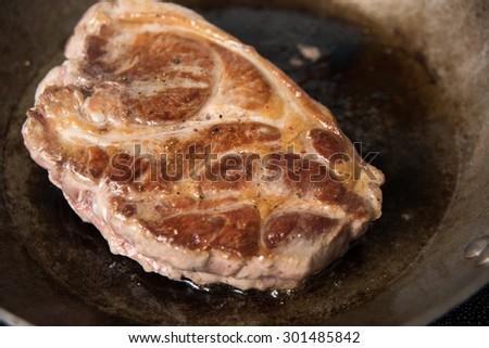 Browning Piece of Pork Shoulder on Seasoned Skillet