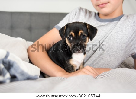 Child Protecting Black Puppy with Floppy Ears