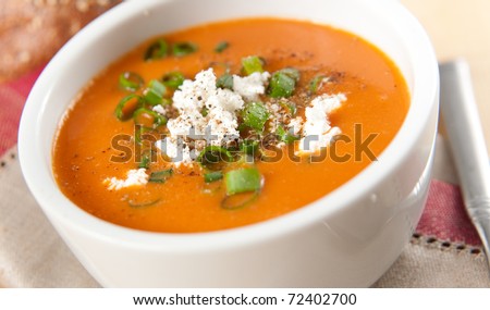 Small Bowl of Pepper and Tomato Creamy Soup with Green Onions and Goat Cheese