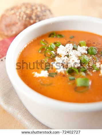 Small Bowl of Pepper and Tomato Creamy Soup with Green Onions and Goat Cheese