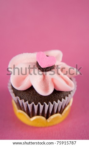 Cute Chocolate Cupcake with Pink Strawberry Icing and Tiny Heart Candy on Top